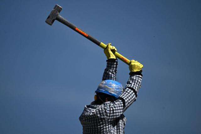 A man helps remove debris in Cali, Colombia, on August 13, 2026, three days after a 7.4 earthquake. Rescuers in Colombia were making last-ditch efforts to locate earthquake survivors early on August 13, 2026, as the critical 72-hour window for rescue operations neared its end. (Photo by Raul ARBOLEDA / AFP)