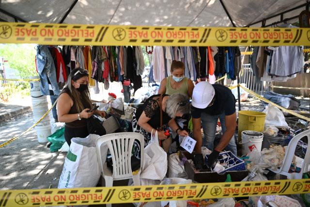 Relatives of missing people look for belongings of their loved ones in Cali, Colombia, on August 13, 2026, three days after a 7.4 earthquake. Rescuers in Colombia were making last-ditch efforts to locate earthquake survivors early on August 13, 2026, as the critical 72-hour window for rescue operations neared its end. (Photo by Raul ARBOLEDA / AFP)