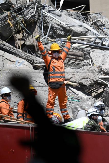 Rescuers call for silence in the search for survivors amid the rubble of a collapsed building in Cali, Colombia, on August 13, 2026, three days after a 7.4 earthquake. Rescuers in Colombia were making last-ditch efforts to locate earthquake survivors early on August 13, 2026, as the critical 72-hour window for rescue operations neared its end. (Photo by Joaquin SARMIENTO / AFP)