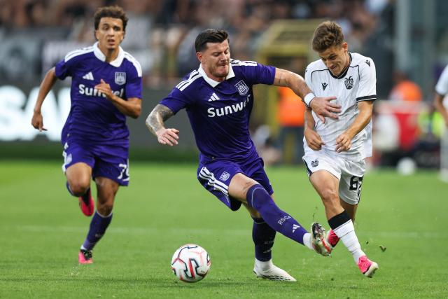 Anderlecht's French defender #04 Giulian Biancone (C) and PAOK's Greek midfielder #65 Giannis Konstantelias (R) fight for the ball during the UEFA Europa League third qualifying round - second leg football match between RSC Anderlecht and PAOK Thessaloniki at Lotto Park in Brussels on August 13, 2026. (Photo by BRUNO FAHY / Belga / AFP) / Belgium OUT