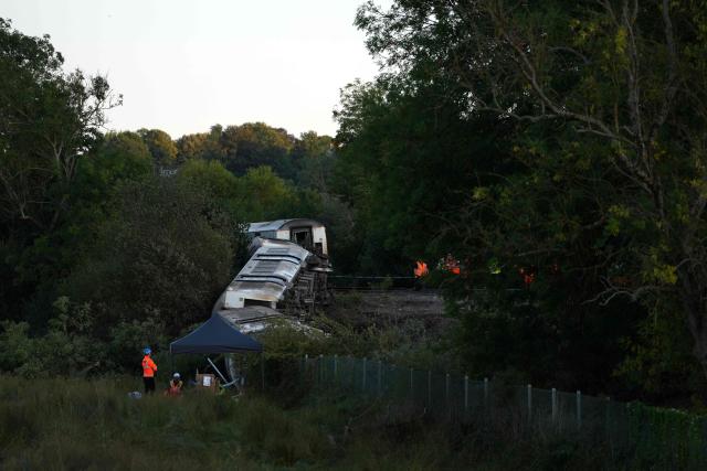 Carriages of a derailed train are pictured on their side, near the town of Lewes, southern England on August 13, 2026. Two people sustained "serious injuries" and nine more were hurt as a busy commuter train from London derailed on August 13, near the southeast English town of Lewes, emergency services said. (Photo by CARLOS JASSO / AFP)