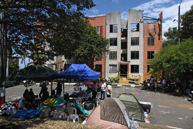 People camp in front of their damaged home at the Altos de Santa Elena neighborhood in Cali, Colombia, on August 13, 2026, three days after a 7.4 earthquake. Rescuers in Colombia were making last-ditch efforts to locate earthquake survivors early on August 13, 2026, as the critical 72-hour window for rescue operations neared its end. (Photo by JOAQUIN SARMIENTO / AFP)
