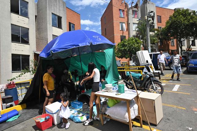 People camp in front of their damaged home at the Altos de Santa Elena neighborhood in Cali, Colombia, on August 13, 2026, three days after a 7.4 earthquake. Rescuers in Colombia were making last-ditch efforts to locate earthquake survivors early on August 13, 2026, as the critical 72-hour window for rescue operations neared its end. (Photo by JOAQUIN SARMIENTO / AFP)