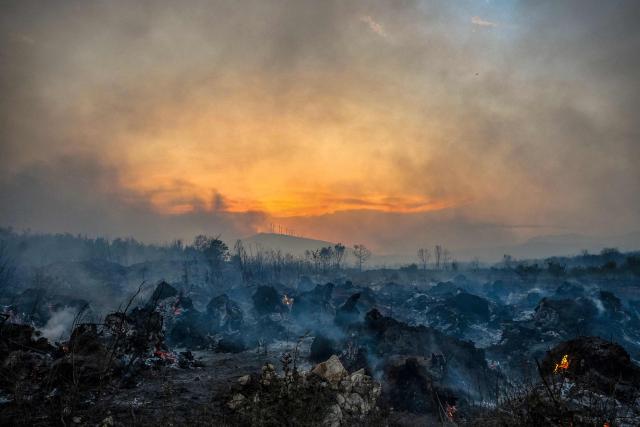 Smoke rises from a forest scorched by a wildfire near the village of Zogaj, close to the coastal town of Ulcinj, Montenegro, on August 13, 2026. (Photo by SAVO PRELEVIC / AFP)