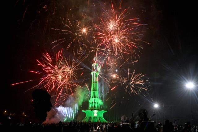 People watch fireworks explode over the Minar-e-Pakistan national monument during celebrations ahead of Pakistan's 79th anniversary of Independence Day in Lahore on August 14, 2026. (Photo by Arif ALI / AFP)
