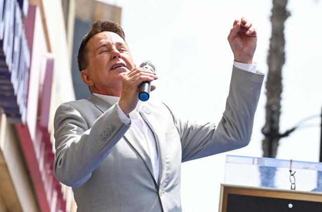 US stage actor and baritone Davis Gaines sings during Orel Hershiser's Walk of Fame star ceremony in the Hollywood neighborhood of Los Angeles on August 13, 2026. (Photo by Katie FLORES / AFP)