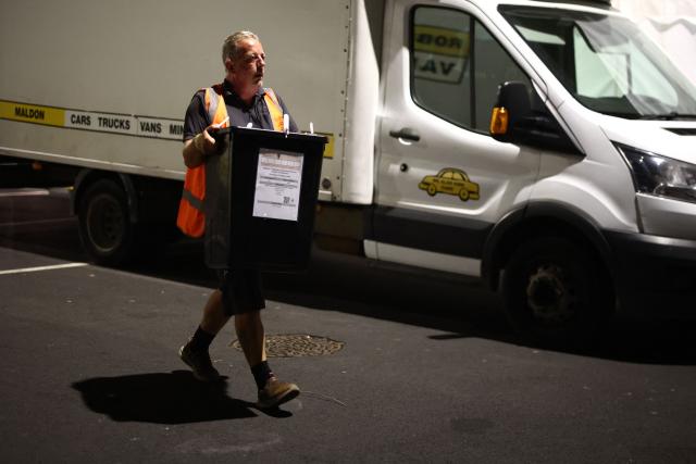 A ballot box is carried into the count centre venue for the by-election of the parliamentary seat of Clacton, at Clacton Leisure Centre, eastern England on August 13, 2026. Voters in eastern England headed to the polls on August 13 for a by-election triggered by hard-right Reform UK leader Nigel Farage. (Photo by Henry Nicholls / AFP)