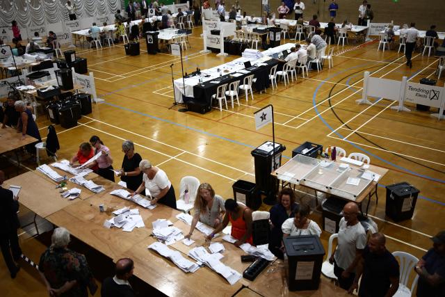 Ballots are counted at the count centre venue for the by-election of the parliamentary seat of Clacton, at Clacton Leisure Centre, eastern England on August 13, 2026. Voters in eastern England headed to the polls on August 13 for a by-election triggered by hard-right Reform UK leader Nigel Farage. (Photo by Henry Nicholls / AFP)