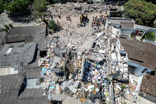This aerial view shows rescuers searching for survivors amid the rubble of a collapsed building three days after a 7.4 earthquake in Pereira, Colombia on August 13, 2026. Rescuers in Colombia were making last-ditch efforts to locate earthquake survivors early on August 13, 2026, as the critical 72-hour window for rescue operations neared its end. (Photo by Luis ACOSTA / AFP)