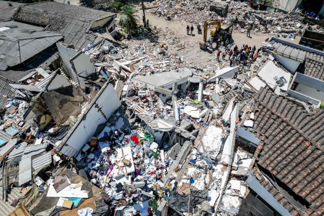 This aerial view shows rescuers searching for survivors amid the rubble of a collapsed building three days after a 7.4 earthquake in Pereira, Colombia on August 13, 2026. Rescuers in Colombia were making last-ditch efforts to locate earthquake survivors early on August 13, 2026, as the critical 72-hour window for rescue operations neared its end. (Photo by Luis ACOSTA / AFP)