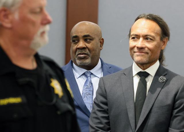 Duane Davis (C) stands with his attorney Michael Sanft as prospective jurors enter the courtroom during the fourth day of jury selection in his murder trial, related to the 1996 killing of rapper Tupac Shakur, at Clark County District Court Regional Justice Center in Las Vegas, Nevada, on August 13, 2026. The trial of the former gang leader accused of orchestrating the murder of rapper Tupac Shakur finally began on August 10, 30 years after one of America's most high-profile unresolved killings. The proceedings, expected to last a month, will likely not make clear who fired the shots that killed the California hip-hop legend on the night of September 7, 1996, while he was in Las Vegas to see a Mike Tyson boxing match. (Photo by Bizuayeha TESFAYE / POOL / AFP)