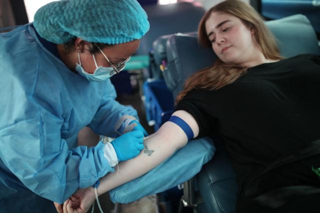 A woman donates blood at the IDCBIS District Blood Bank in Bogota on August 13, 2026, as volunteers donate blood for people affected by the August 10 earthquake. Rescuers in Colombia were making last-ditch efforts to locate earthquake survivors early on August 13, as the critical 72-hour window for rescue operations neared its end. (Photo by ESTEBAN VEGA LA-ROTTA / AFP)