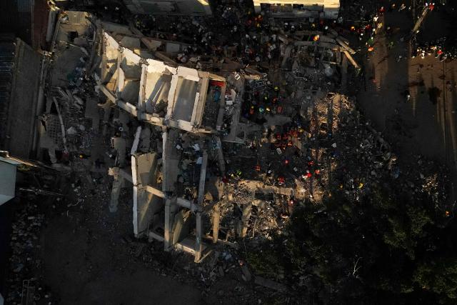 This aerial view shows the rubble of a collapsed building in Cali, Colombia, on August 13, 2026, three days after a 7.4-magnitude earthquake. Rescuers in Colombia were making last-ditch efforts to locate earthquake survivors early on August 13, 2026, as the critical 72-hour window for rescue operations neared its end. (Photo by Raul ARBOLEDA / AFP)