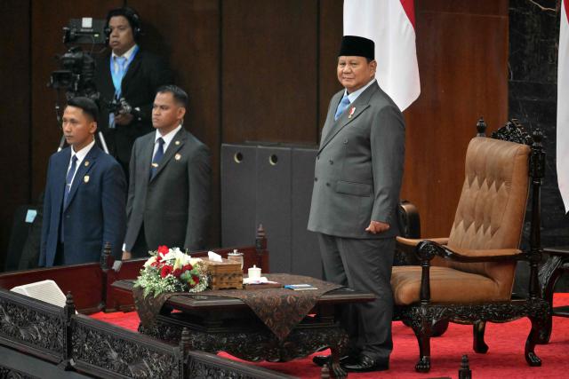 Indonesia's President Prabowo Subianto (R) arrives to deliver his annual State of the Nation Address, ahead of the country's Independence Day celebrations, in Jakarta on August 14, 2026. (Photo by Bay ISMOYO / AFP)