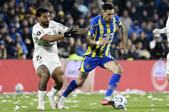 Corinthians' defender #21 Matheus Bidu and Rosario Central's forward #11 Angel Di Maria fight for the ball during the first leg of the Copa Libertadores round of 16 football match between Argentina's Rosario Central and Brazil's Corinthians at the Gigante de Arroyito stadium in Rosario, Santa Fe province, Argentina, on August 13, 2026. (Photo by Marcelo Manera / AFP)