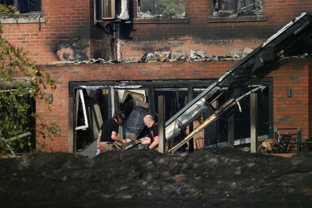 Firefighters work at the site of a fire-damaged house in Stourbridge, south-west of Birmingham, central England on August 14, 2026. Firefighters continued Friday to extinguish fires that began on August 13, tearing through several homes, with residents evacuated and "extensive" damage reported. (Photo by Darren Staples / AFP)