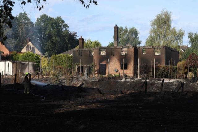 Firefighters work at the site of a fire-damaged house in Stourbridge, south-west of Birmingham, central England on August 14, 2026. Firefighters continued Friday to extinguish fires that began on August 13, tearing through several homes, with residents evacuated and "extensive" damage reported. (Photo by Darren Staples / AFP)