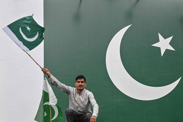 A supporter of the Pakistan Markazi Muslim League (PMML) waves the country's national flag during a rally to celebrate Independence Day in Lahore on August 14, 2026. (Photo by Arif ALI / AFP)