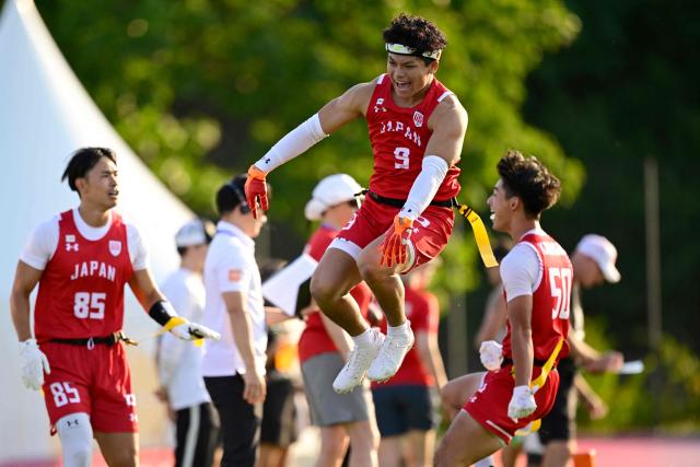 Japan's Haruki Suzuki celebrates with team mates during the men's match between Japan and Canada at the "IFAF World Flag" World Championship in flag football in Duesseldorf, western Germany, on August 14, 2026. (Photo by Ina FASSBENDER / AFP)