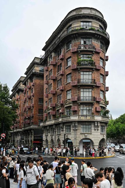 People gather next to the Wukang Mansion, a protected historic building, in the Xuhui district in Shanghai on August 14, 2026. (Photo by Hector RETAMAL / AFP)
