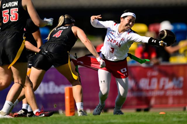 Japan's Miyuna Yamamoto (R) and Canada's Rosalie Landry fight for the ball during the women's match between Japan and Canada at the "IFAF World Flag" World Championship in flag football in Duesseldorf, western Germany, on August 14, 2026. (Photo by Ina FASSBENDER / AFP)