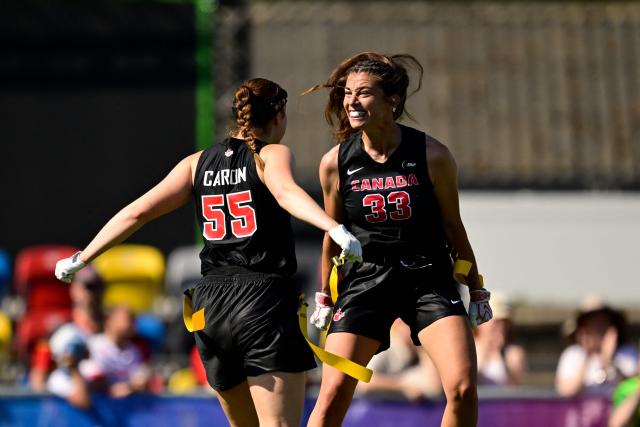 Japan's Laurence Marie Jeanne Caron (L) and Canada's Catherine Gaumont celebrate during the women's match between Japan and Canada at the "IFAF World Flag" World Championship in flag football in Duesseldorf, western Germany, on August 14, 2026. (Photo by Ina FASSBENDER / AFP)
