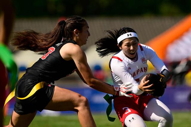 Canada's Catherine Gaumont and Japan's Miyuna Yamamoto (R) fight for the ball during the women's match between Japan and Canada at the "IFAF World Flag" World Championship in flag football in Duesseldorf, western Germany, on August 14, 2026. (Photo by Ina FASSBENDER / AFP)