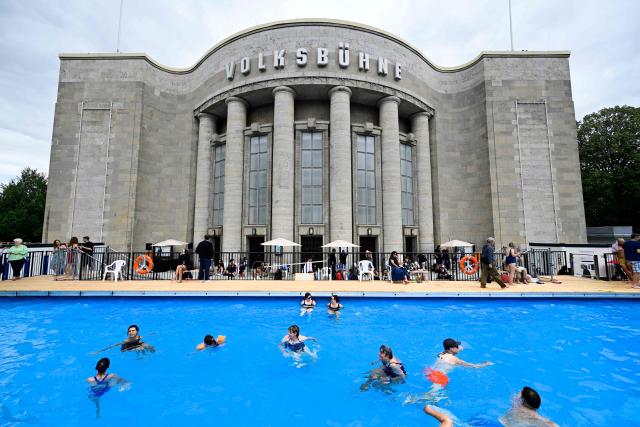 (FILES) Visitors swim in the so-called "Volksbad" swimming pool set up in front of the Volksbuehne theatre at Rosa-Luxemburg-Platz square in Berlin on August 7, 2026, on the day of its opening. The Volksbuehne scrapped plans on August 14, 2026 to reserve the pool for black children and young people for one afternoon, citing a backlash and security fears sparked by "racist agitation". The Volksbuehne theatre and the anti-racism organisation Each One Teach One (EOTO) had intended the event, for black "children, young people and their relatives", as "a positive measure to support structurally disadvantaged groups". However, they said this had sparked inflammatory media coverage as well as racist emails and threats of violence that had raised safety concerns. (Photo by John MACDOUGALL / AFP)