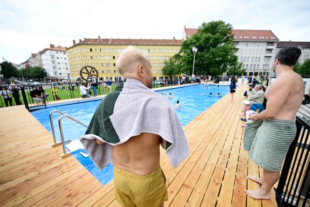 (FILES) Visitors dry themselves after a swim in the so-called "Volksbad" swimming pool set up in front of the Volksbuehne theatre at Rosa-Luxemburg-Platz square in Berlin on August 7, 2026, on the day of its opening. The Volksbuehne scrapped plans on August 14, 2026 to reserve the pool for black children and young people for one afternoon, citing a backlash and security fears sparked by "racist agitation". The Volksbuehne theatre and the anti-racism organisation Each One Teach One (EOTO) had intended the event, for black "children, young people and their relatives", as "a positive measure to support structurally disadvantaged groups". However, they said this had sparked inflammatory media coverage as well as racist emails and threats of violence that had raised safety concerns. (Photo by John MACDOUGALL / AFP)