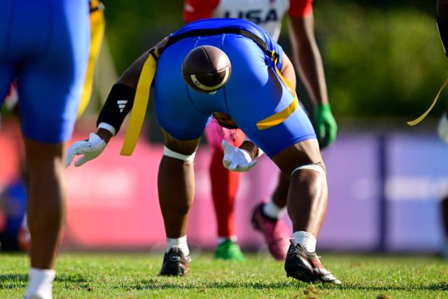 A player of American Samoa throws the ball between his legs during the men's match between American Samoa and the US at the "IFAF World Flag" World Championship in flag football in Duesseldorf, western Germany, on August 14, 2026. (Photo by Ina FASSBENDER / AFP)