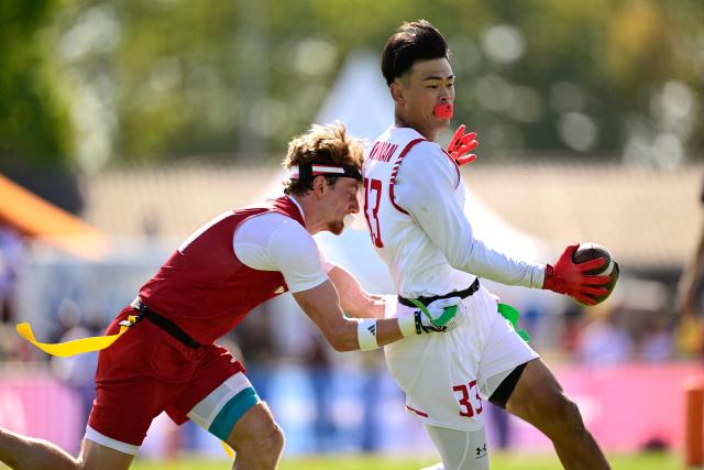 Japan's Tsubasa Brennan (R) and Austria's Leonhart Gerner fight for the ball during the men's match between Austria and Japan at the "IFAF World Flag" World Championship in flag football in Duesseldorf, western Germany, on August 14, 2026. (Photo by Ina FASSBENDER / AFP)