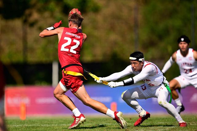 Japan's Ryohei Uematsu (R) and Austria's Valentin Ehrenfried fight for the ball during the men's match between Austria and Japan at the "IFAF World Flag" World Championship in flag football in Duesseldorf, western Germany, on August 14, 2026. (Photo by Ina FASSBENDER / AFP)