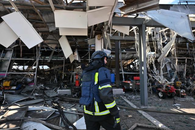 Firefighters work on the grounds of a burned DIY and construction materials mall following an overnight attack, which local Russian-installed officials called Ukrainian drone strikes, in Yenakiyeve in the Donetsk region, Russian-controlled Ukraine, on August 14, 2026, amid the ongoing Russian-Ukrainian conflict. (Photo by AFP)