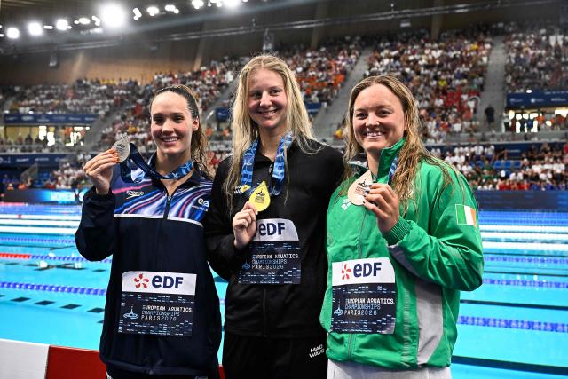 Gold medallist  Neutral Dthlete B's Evegeniia Chikunova (C), silver medallist Britain's Angharad Evans (L) and bronze medallist Ireland's Mona Mc Sharry (R) pose on the podium of the women's 200m breaststroke swimming event during the LEN European Aquatics Championships at the Olympic Aquatic Centre in Saint-Denis, northern suburbs of Paris, on August 14, 2026. (Photo by JULIEN DE ROSA / AFP)