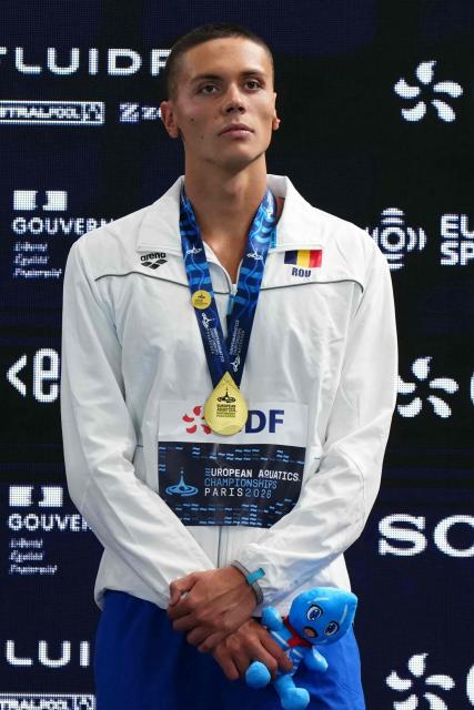 Romania's David Popovici poses with his gold medal on the podium of the men's 200m freestyle swimming event during the LEN European Aquatics Championships at the Olympic Aquatic Centre in Saint-Denis, northern suburbs of Paris, on August 14, 2026. (Photo by Dimitar DILKOFF / AFP)