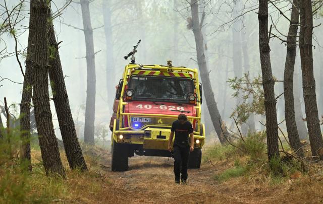 French firefighters work in a forest during a wildfire in Luglon, south-western France on August 14, 2026. (Photo by Gaizka IROZ / AFP)