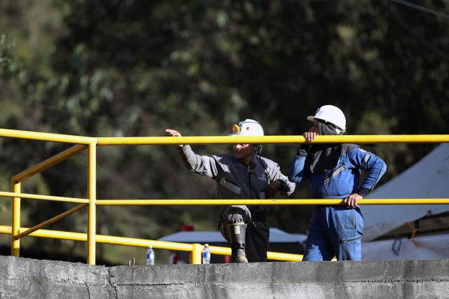 Miners stand outside the El Porvenir 1 mine, where six workers died following an explosion, in La Ramada, Cundinamarca department, Colombia, on August 14, 2026. Six workers at a mine in central Colombia were found dead by rescuers on August 14 after being trapped by an explosion, departmental authorities said. (Photo by ESTEBAN VEGA LA-ROTTA / AFP)