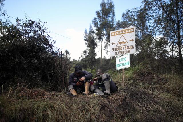 Miners sit outside the El Porvenir 1 mine, where six workers died following an explosion, in La Ramada, Cundinamarca department, Colombia, on August 14, 2026. Six workers at a mine in central Colombia were found dead by rescuers on August 14 after being trapped by an explosion, departmental authorities said. (Photo by ESTEBAN VEGA LA-ROTTA / AFP)