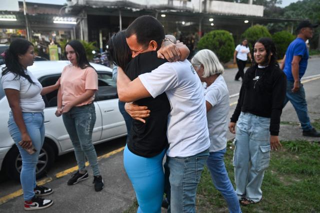 Former political prisoner Angela Vasquez embraces her brother after her release outside El Rodeo I prison in Guatire, Miranda state, Venezuela, on August 14, 2026. Venezuela released 131 political prisoners on August 14, including a woman accused of involvement in an alleged drone attack against ousted leader Nicolas Maduro, following a pledge made the previous day by the opposition representative in talks with the interim government to help secure their release. (Photo by Juan BARRETO / AFP)