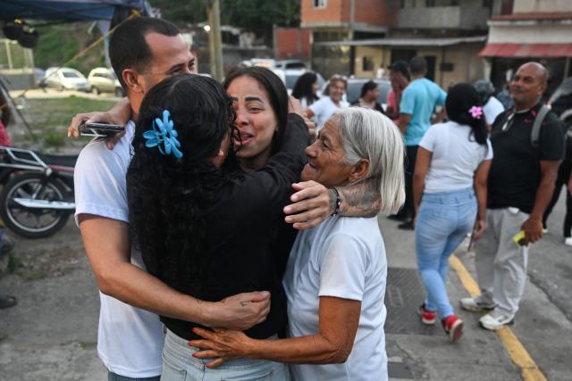 Former political prisoner Angela Vasquez (C) embraces relatives after her release outside El Rodeo I prison in Guatire, Miranda state, Venezuela, on August 14, 2026. Venezuela released 131 political prisoners on August 14, including a woman accused of involvement in an alleged drone attack against ousted leader Nicolas Maduro, following a pledge made the previous day by the opposition representative in talks with the interim government to help secure their release. (Photo by Juan BARRETO / AFP)