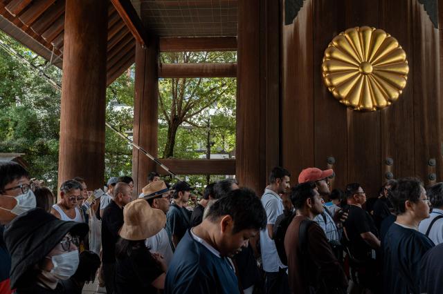 People queue up to pay their respect during a visit to the Yasukuni Shrine in Tokyo on August 15, 2026, on the 81st anniversary of Japan's surrender in World War II. Yasukuni is dedicated to 2.5 million war dead, mostly Japanese, including convicted war criminals involved in Imperial Japan's invasion and occupation of parts of Asia in the 1930s and 1940s. (Photo by Philip FONG / AFP)