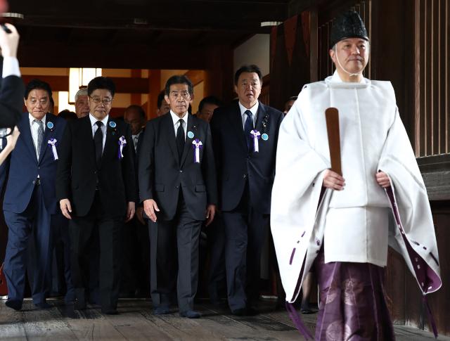 A group of Japanese lawmakers follows a Shinto priest during a visit to the Yasukuni Shrine in Tokyo on August 15, 2026, on the 81st anniversary of Japan's surrender in World War II. (Photo by JIJI Press / AFP) / Japan OUT