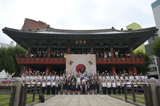 Seoul Mayor Oh Se-hoon (C) and other participants wave South Korean flags during a ceremony to celebrate the 81st anniversary of Korea’s liberation from Japanese colonial rule, at Bosingak Pavilion in Seoul on August 15, 2026. (Photo by Jung Yeon-je / AFP)