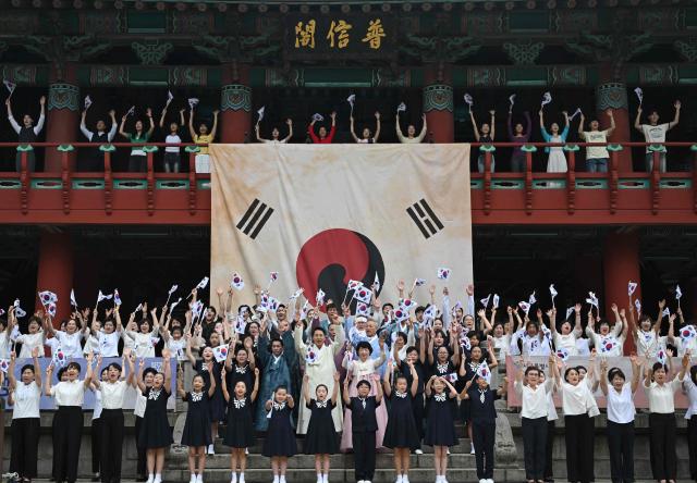 Seoul Mayor Oh Se-hoon (C) and other participants wave South Korean flags during a ceremony to celebrate the 81st anniversary of Korea’s liberation from Japanese colonial rule, at Bosingak Pavilion in Seoul on August 15, 2026. (Photo by Jung Yeon-je / AFP)