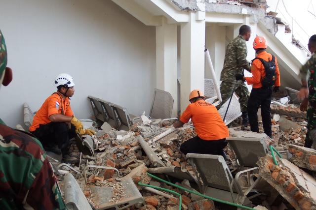 A rescue team searches for victims in the ruins of the Laurensius Say Port in Maumere, Sikka, East Nusa Tenggara on August 15, 2026, after a magnitude 7.7 earthquake struck Flores Island. (Photo by ARNOLD WELIANTO / AFP)