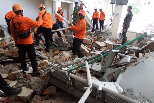 A rescue team searches for victims in the ruins of the Laurensius Say Port in Maumere, Sikka, East Nusa Tenggara on August 15, 2026, after a magnitude 7.7 earthquake struck Flores Island. (Photo by ARNOLD WELIANTO / AFP)