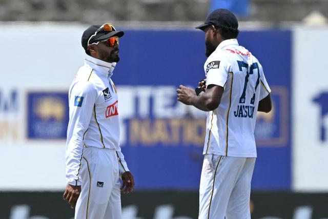 Sri Lanka's captain Dhananjaya de Silva (L) talks with teammate Prabath Jayasuriya (R)  during the first day of the first Test cricket match between Sri Lanka and India at the Galle International Stadium in Galle on August 15, 2026. (Photo by Ishara S. KODIKARA / AFP)