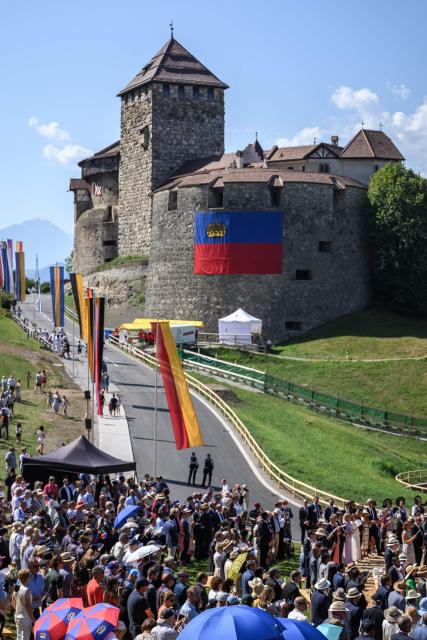 People gather on the slopes below Vaduz Castle, the palace and official residence of the Prince of Liechtenstein, during Liechtenstein's National Day celebrations in Vaduz, on August 15, 2026. Each year on National Day, members of the Princely Family join thousands of residents and visitors for official ceremonies and public celebrations. (Photo by Fabrice COFFRINI / AFP)