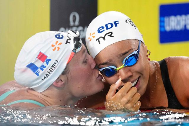 France's Mary-Ambre Moluh (R) celebrates her victory with France's Pauline Mahieu (runner-up) at the end of the final of the women's 100m backstroke swimming event during the LEN European Aquatics Championships at the Olympic Aquatic Centre in Saint-Denis, northern suburbs of Paris, on August 15, 2026. (Photo by SEBASTIEN BOZON / AFP)