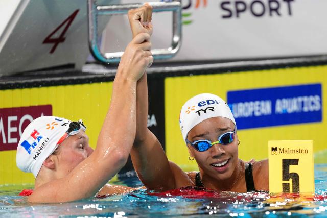 France's Mary-Ambre Moluh (R) celebrates her victory with France's Pauline Mahieu (runner-up) at the end of the final of the women's 100m backstroke swimming event during the LEN European Aquatics Championships at the Olympic Aquatic Centre in Saint-Denis, northern suburbs of Paris, on August 15, 2026. (Photo by SEBASTIEN BOZON / AFP)